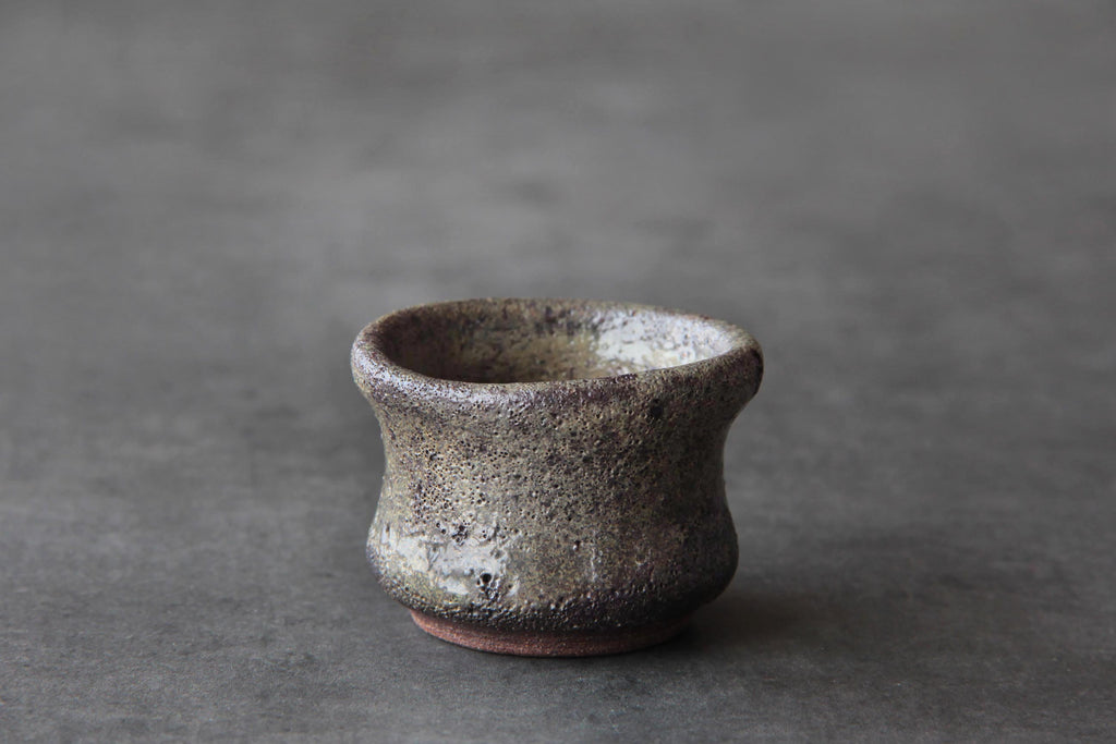 Small Bizen ware sake cup with a rough natural ash glaze texture and earthy brown tones