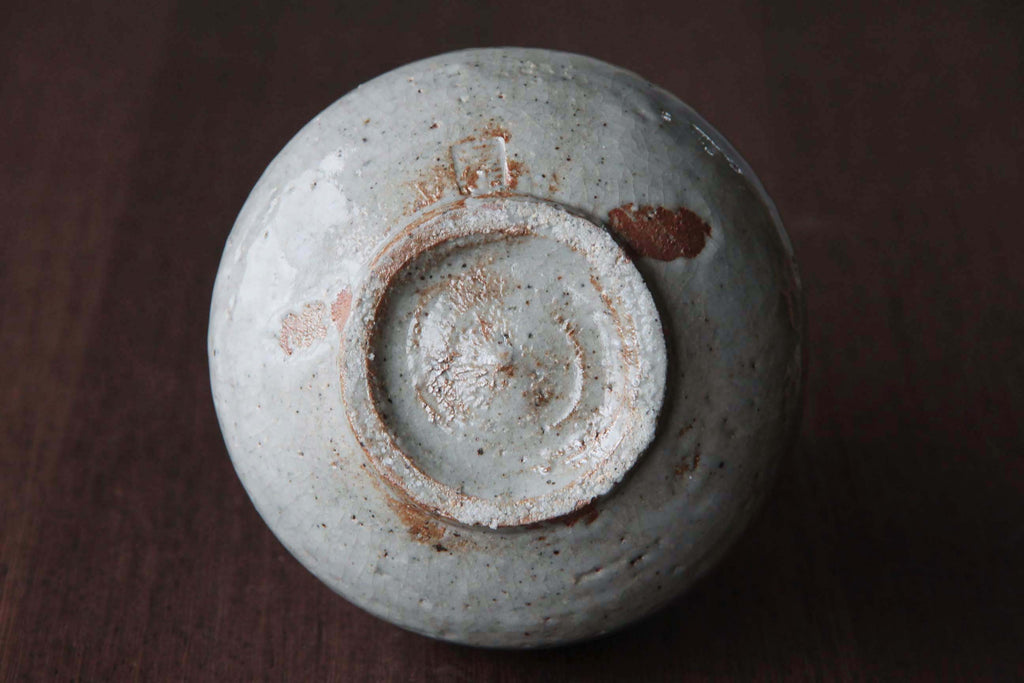 Big size Sake bottle with white glaze. Bottom side view.