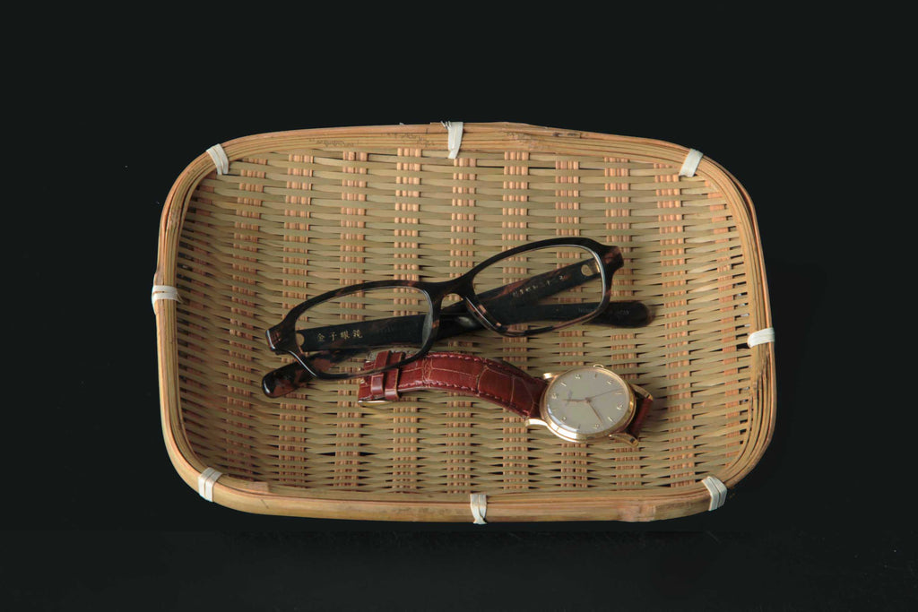 Rectangular bamboo tray used as a storage plate with eyeglasses and a wristwatch inside