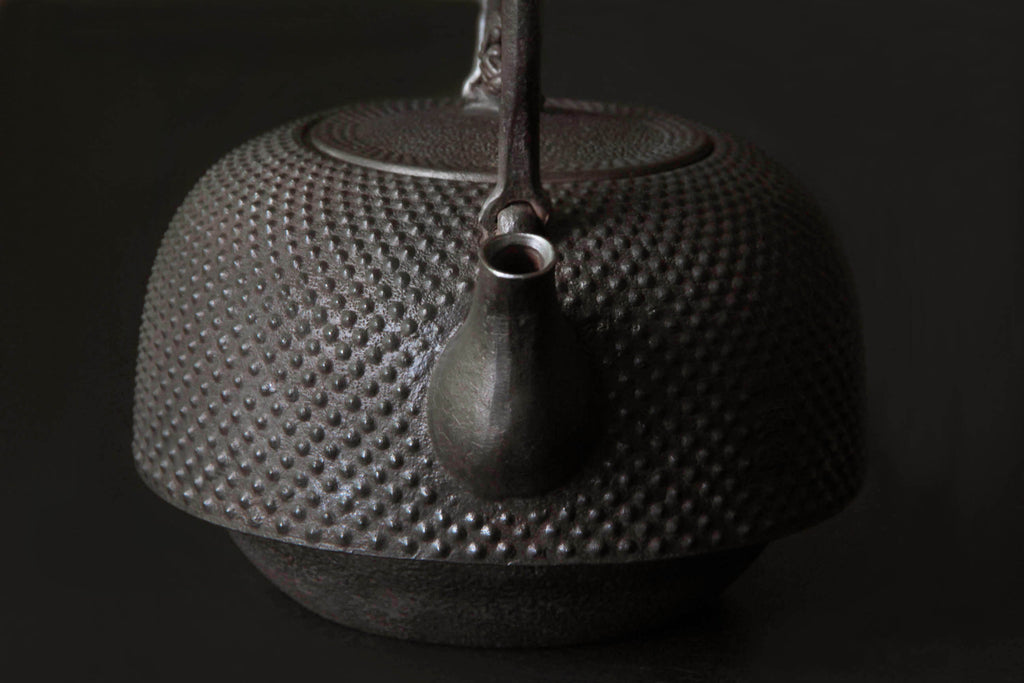 Traditional Nanbu Tekki cast iron kettle
with pinecone-shaped knob and dotted
surface pattern