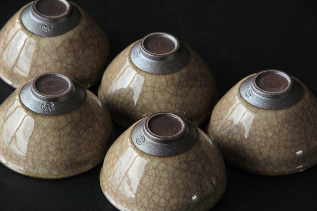 Group of fiveJapanese ceramic tea cups upside down showing foot and maker mark