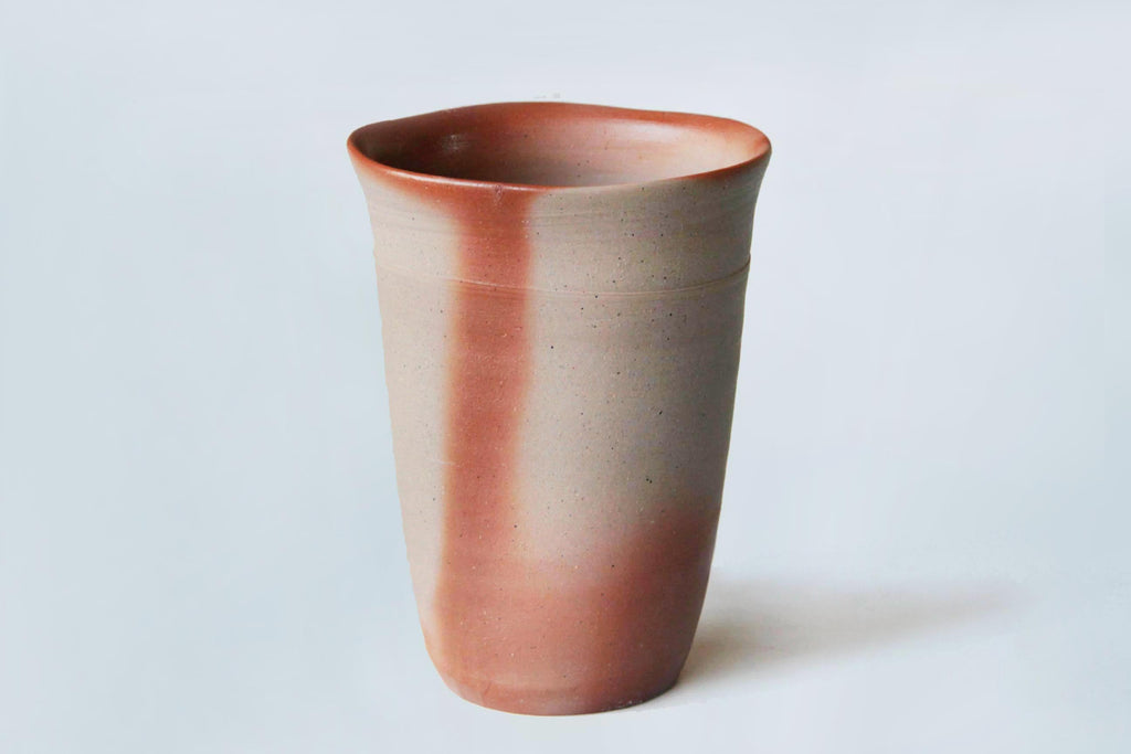 Bizen ware beer tumbler against a white background, showing vibrant natural coloration and texture.