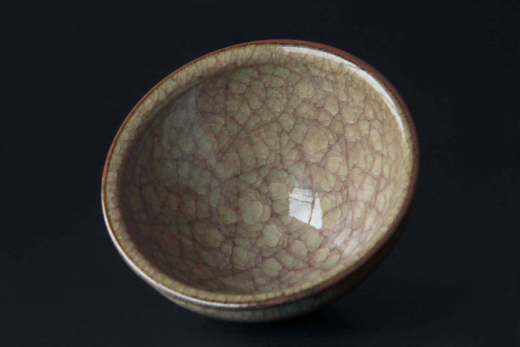 Top view of a single Japanese crackle glaze tea bowl with reflective surface