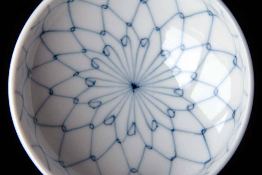 Interior of a bowl showing blue net pattern radiating from the center like a flower