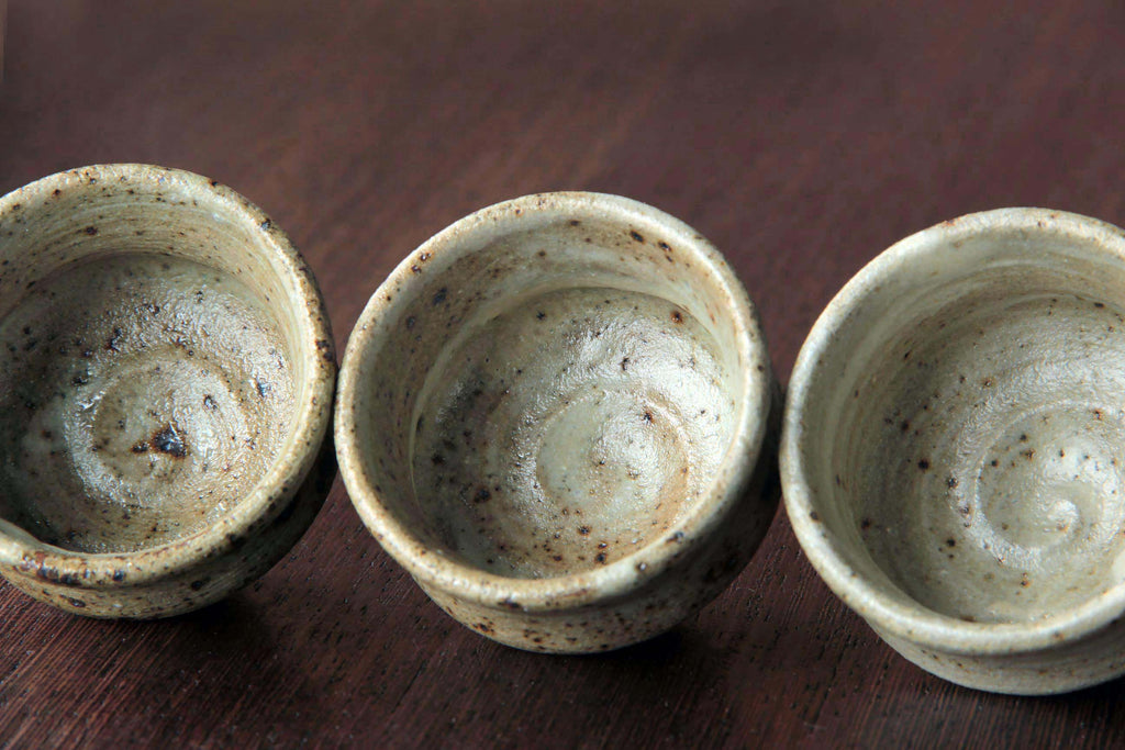 Top view of three Japanese pottery cups, showing spiral
glaze pattern inside.