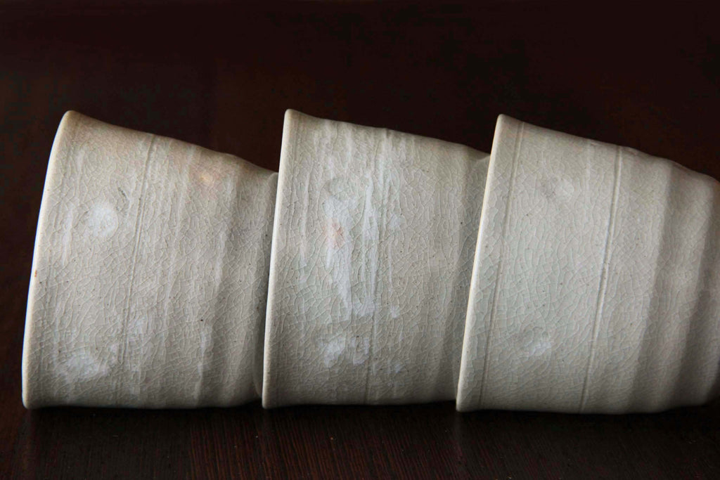 Side view of three tea cups highlighting the natural glaze texture and crackle pattern.