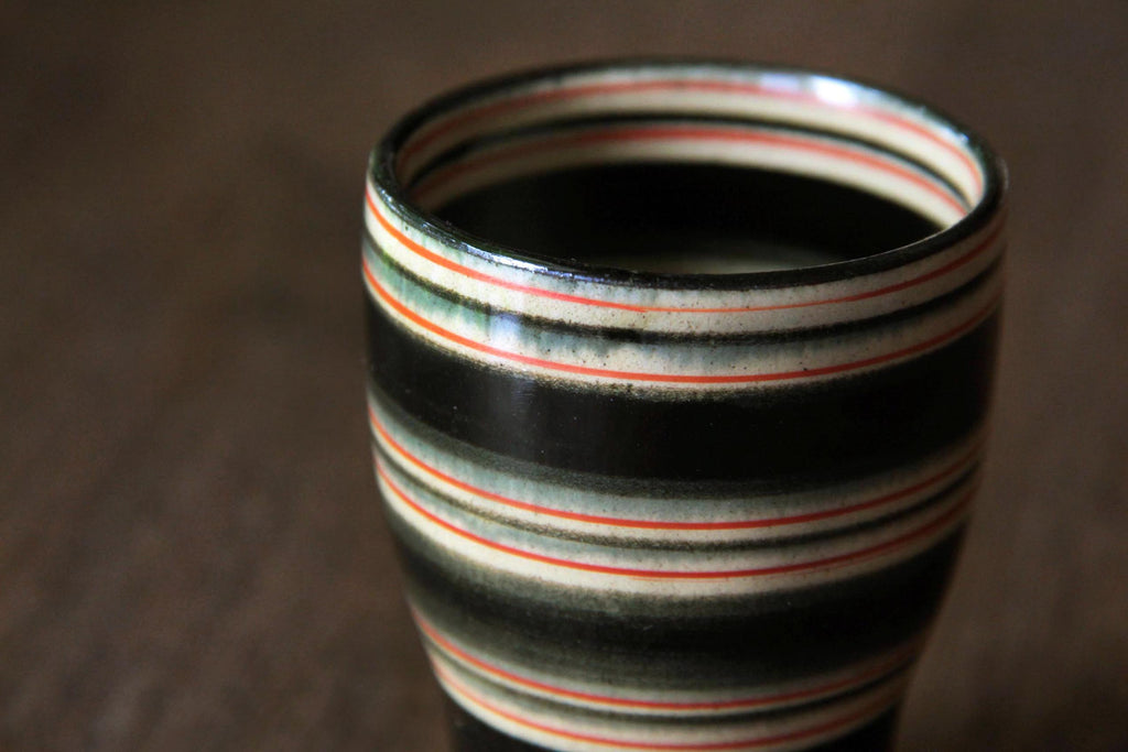 Close-up of the rim and interior of a
Hasami yunomi with vivid black, red, and cream horizontal stripes