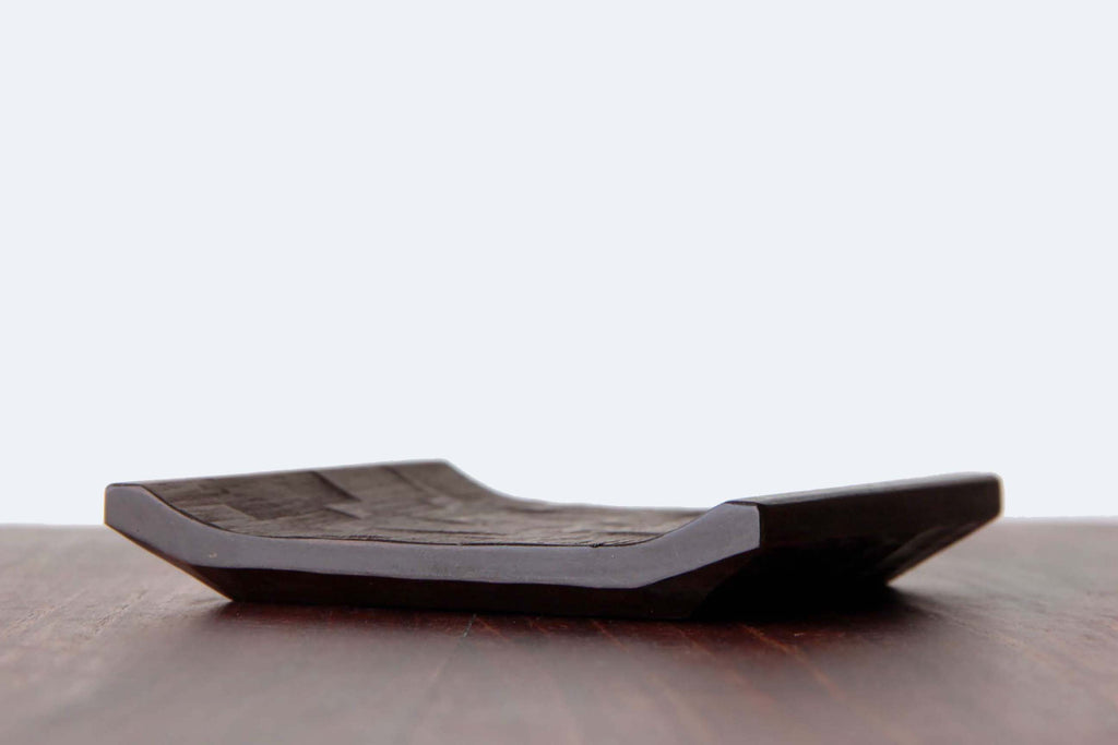 Side view of Japanese wooden plate, showing its flat rectangular form with slightly raised edges.