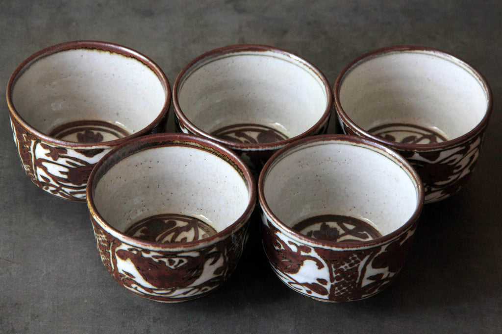 Top-down view of five Japanese tea cups with consistent floral patterns inside and out,
arranged in a semicircle