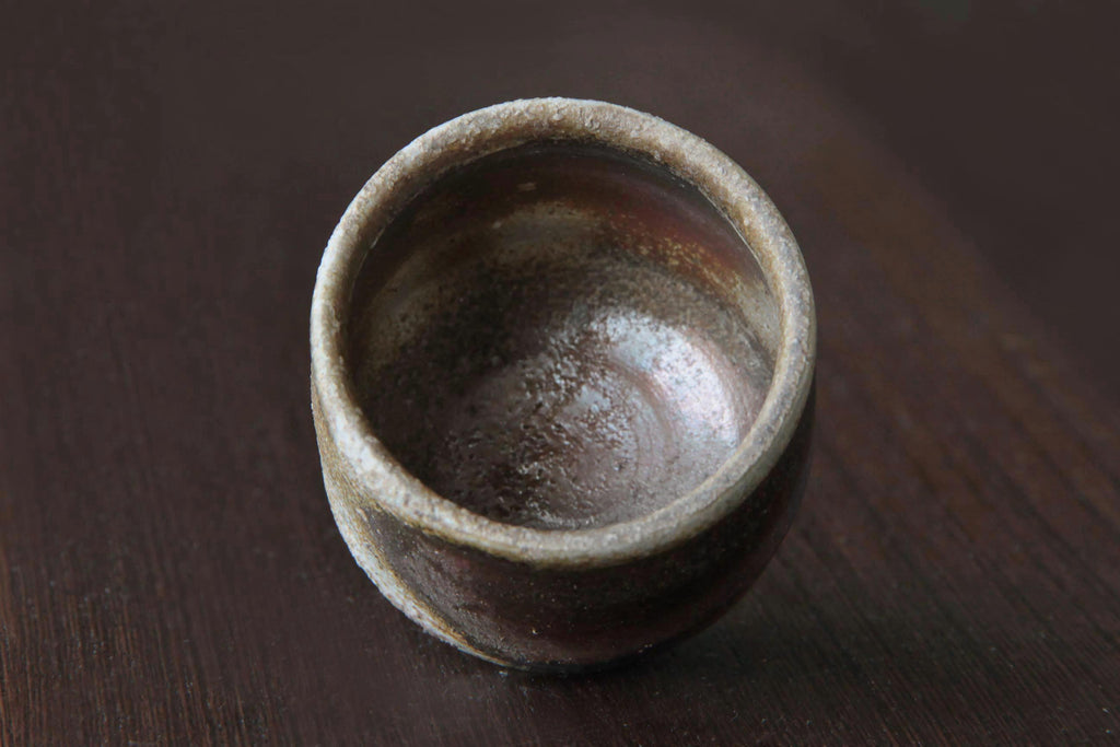 Interior view of Bizen ware sake cup with rough-textured surface and natural earthy brown-red firing tones.
