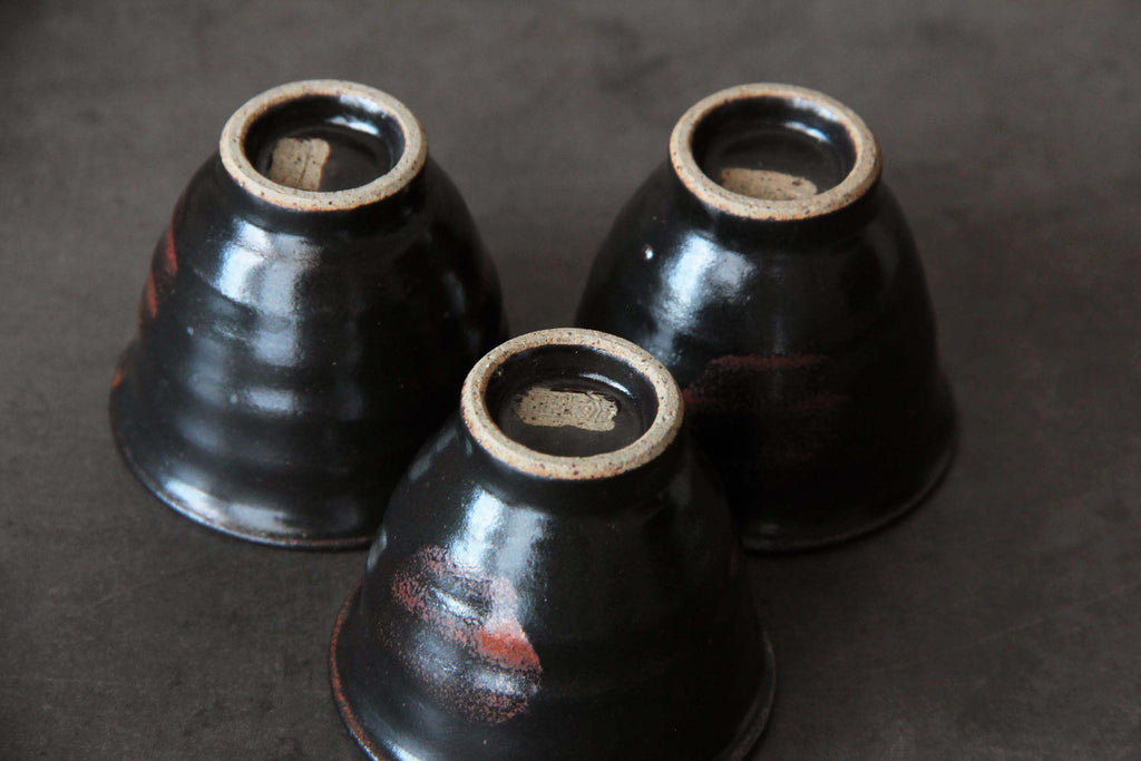 Bottom view of three Satsuma yunomi cups with unglazed foot and studio mark