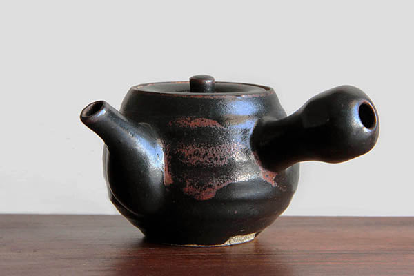Black glaze Satsuma yaki Kyusu tea pot on  wood board.