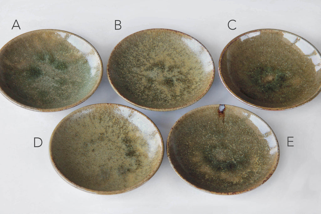Set of five Japanese small dishes labeled A–E, each with unique glaze variations in earthy green and brown tones.