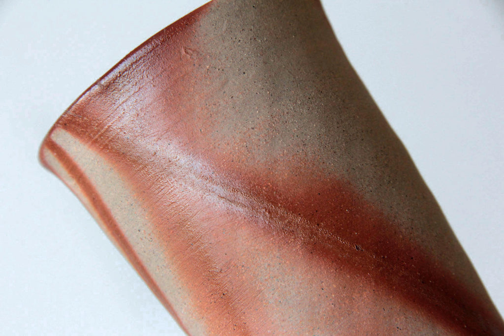 Side view of Bizen tumbler highlighting the unglazed surface texture and reddish burn lines.