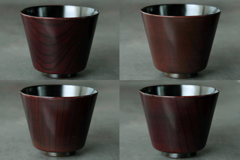 Four lacquer cups viewed from above with inner black lacquer surface visible.