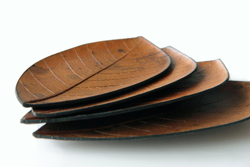 Side view of stacked Japanese leaf plates, highlighting their thin, delicate structure and realistic leaf texture.