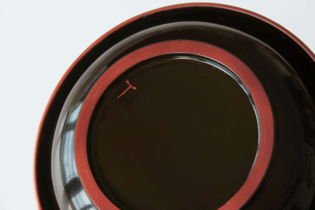 Close up of urushi lacquer bowl rim showing fine vermilion accent and high gloss finish