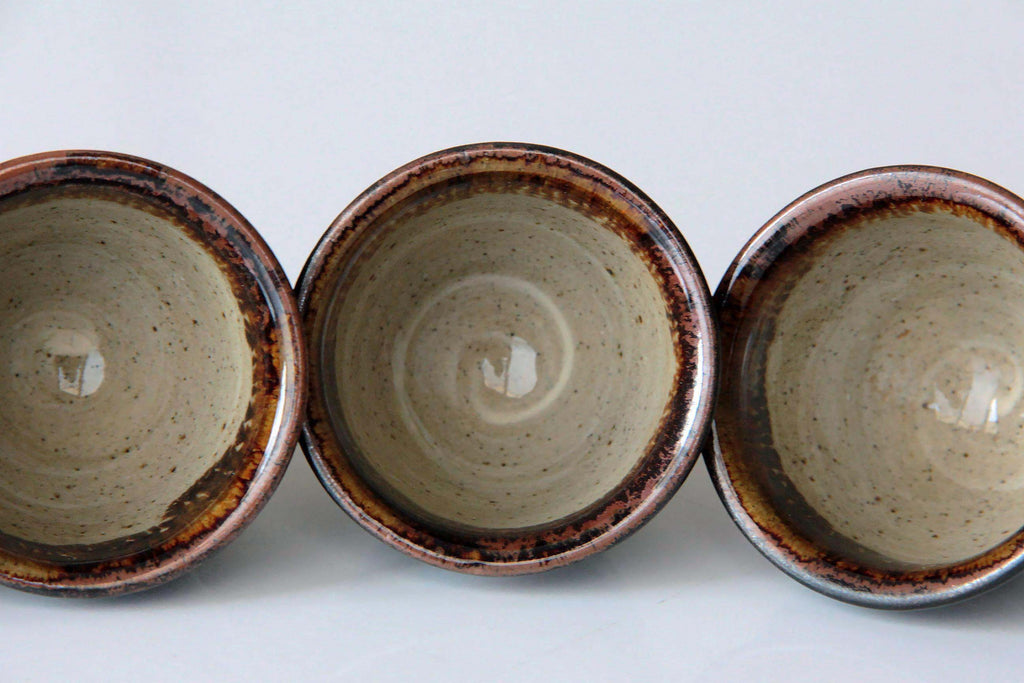 Top view of three Satsuma ware yunomi cups showing light beige interior with a rich brown
rim