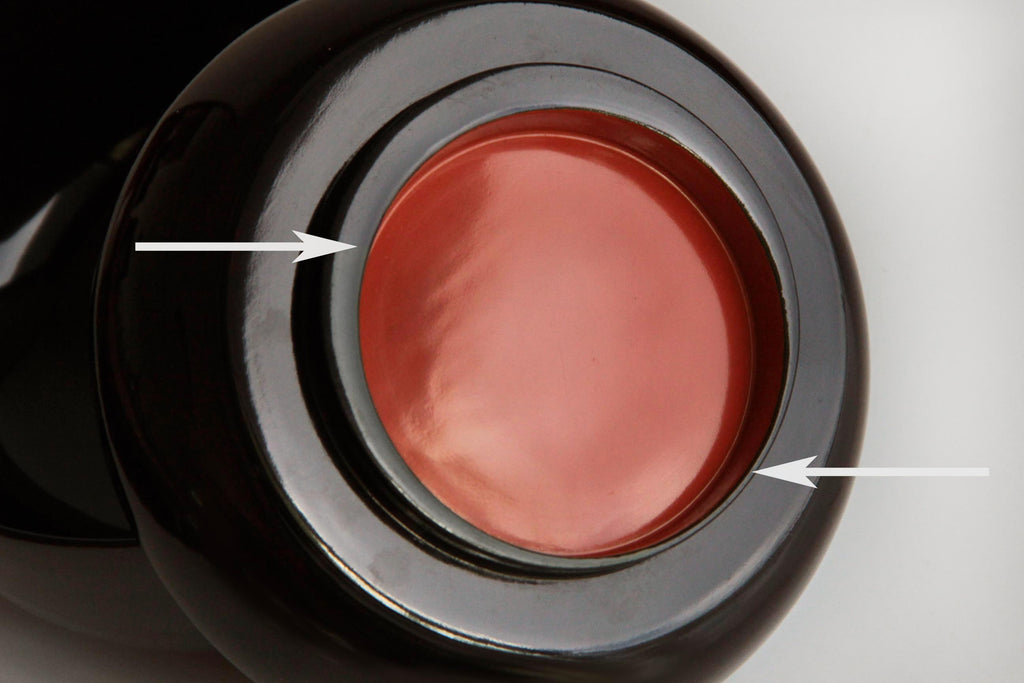Glossy black lacquer soup bowls with vibrant red interiors, arranged neatly.