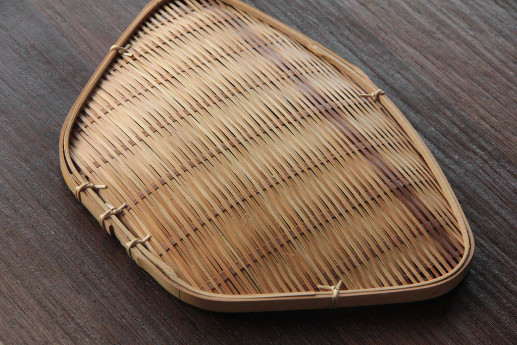 Bamboo tray photographed on a wooden table at an angle showing texture and form
