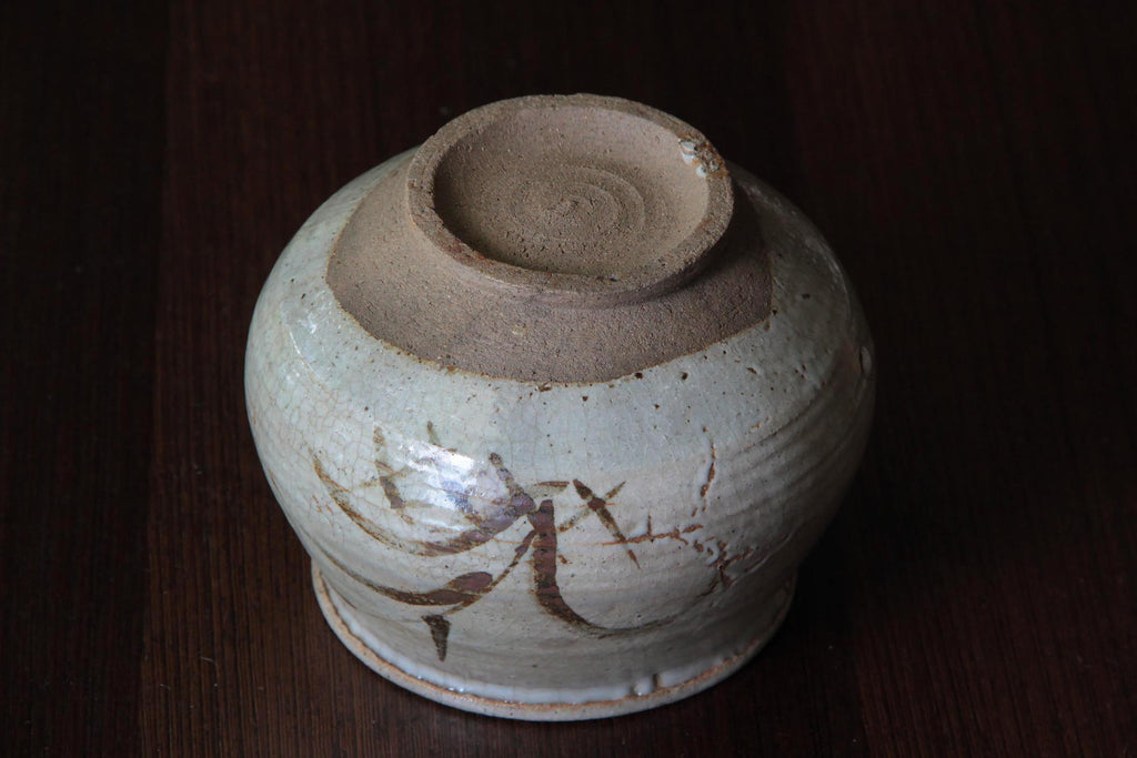 Underside view of the jar showing the coarse foot and clay texture.