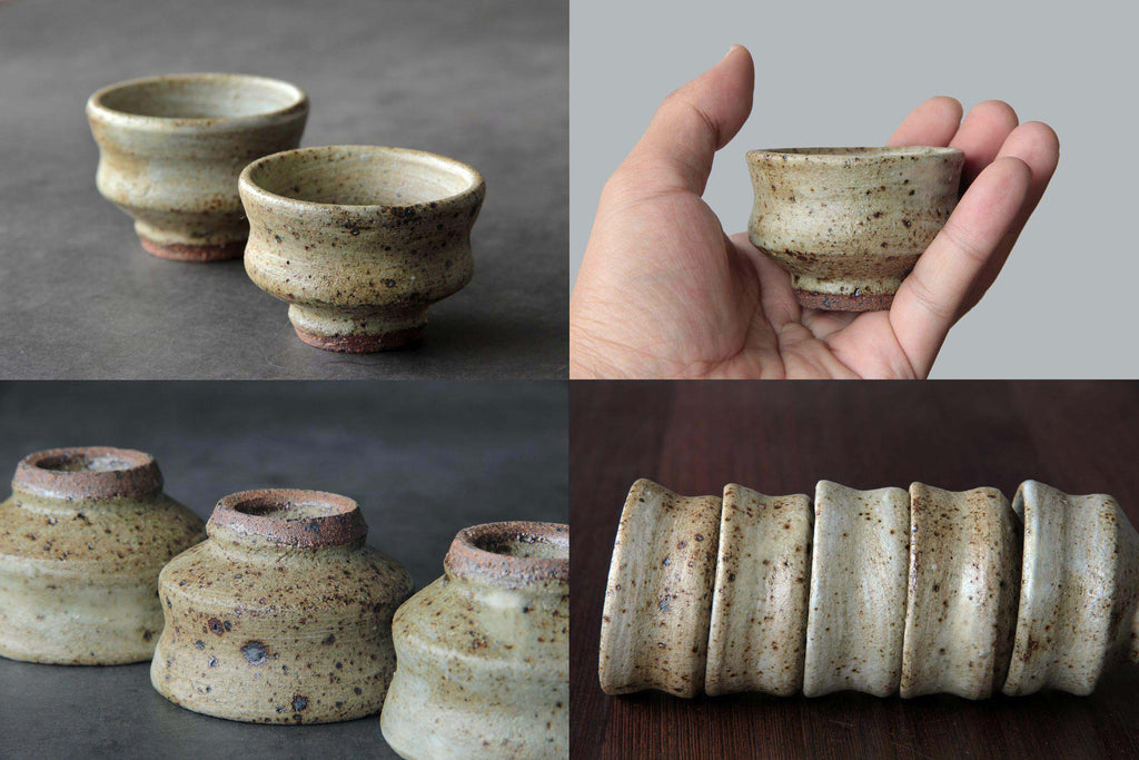 Pair of pottery sake cups, one held in hand, highlighting
small size and rustic feel.