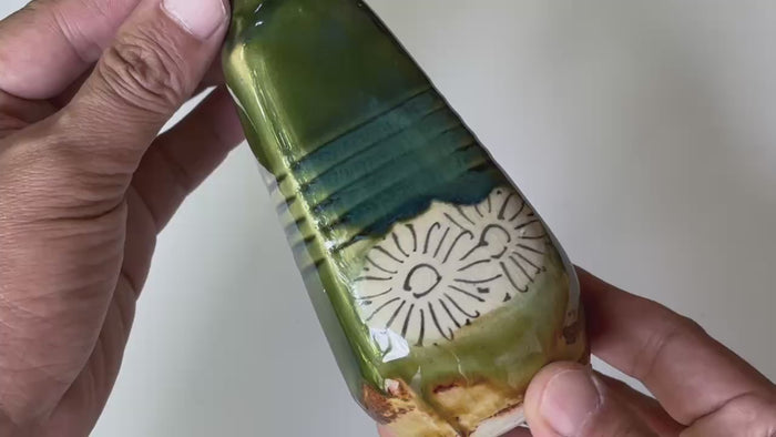 Rotating and close-up video showcasing the shape, texture, and details of the Oribe pottery green bottle.