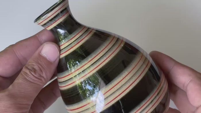 Rotating and close-up video showcasing the shape, texture, and details of the stripped design bottle.