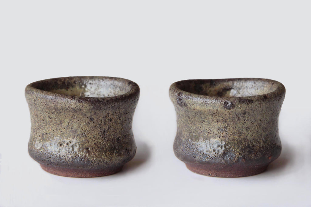 Pair of handcrafted Bizen ware sake cups with rustic ash glaze and irregular surface patterns