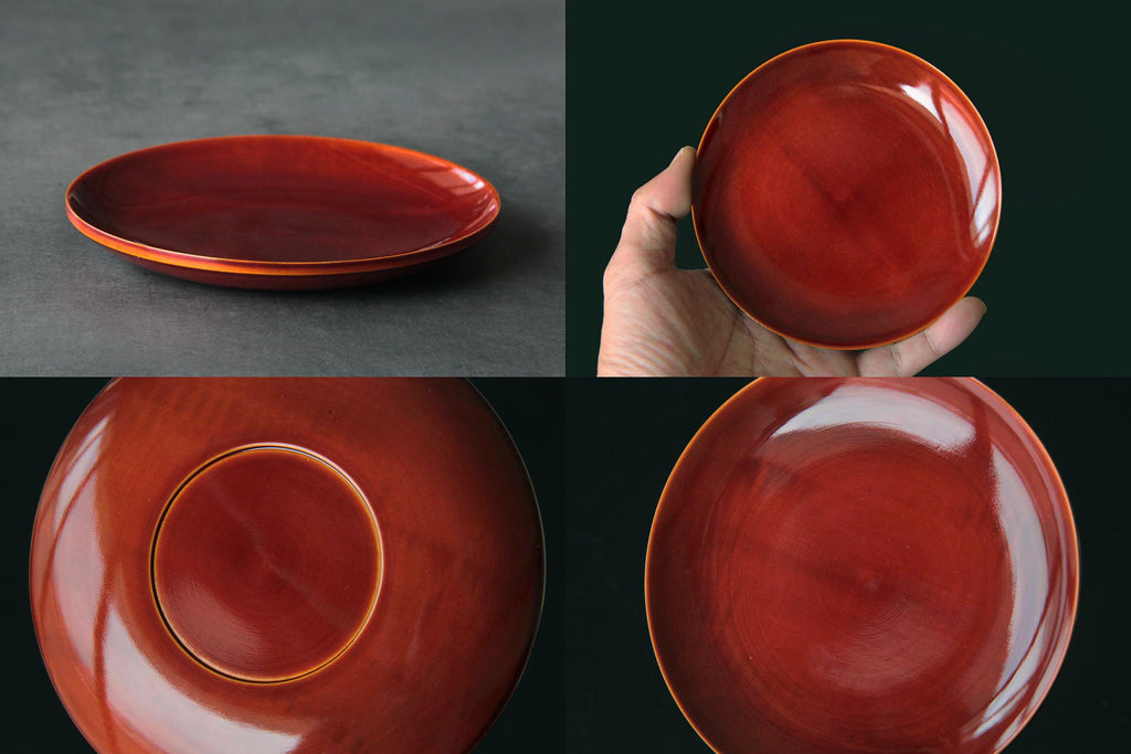 Single Hida Shunkei lacquerware plate held in hand to indicate size and showcasing the
rich reddish-brown lacquer surface