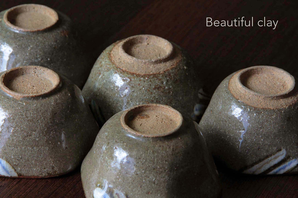 Back view of multiple handmade Karatsu-style bowls showing foot rings and glaze